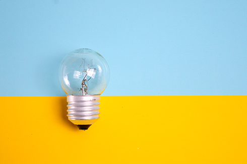 Light bulb on blue and yellow background