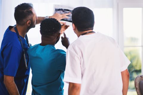 Three doctors looking in to xray