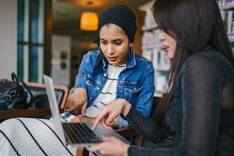 Two girls looking into laptop