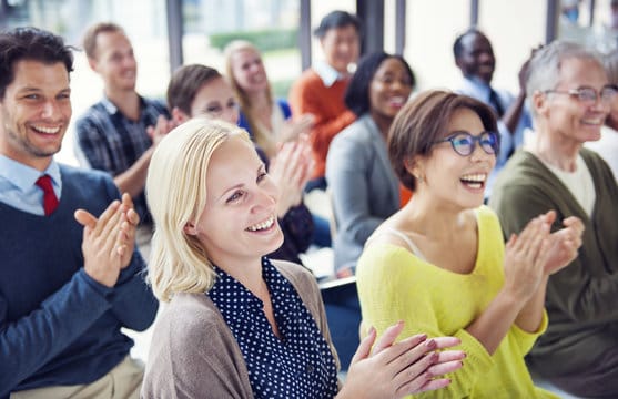 Group of people applauding in a meeting