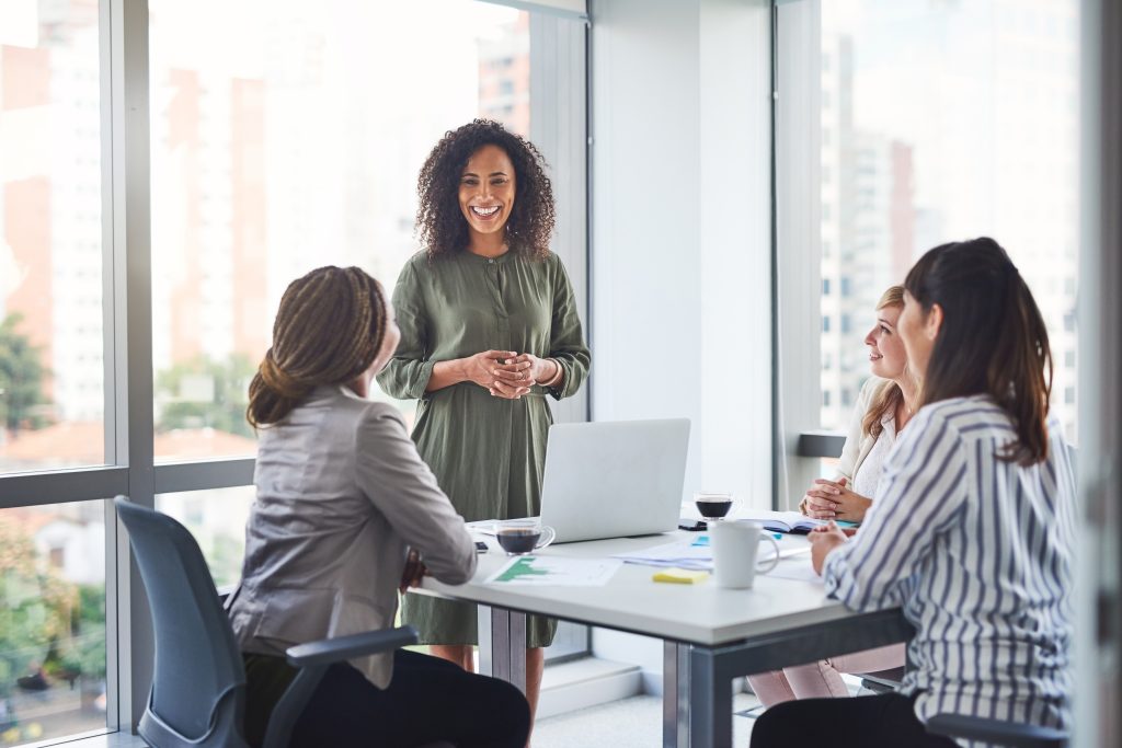 Business women, presentation and meeting with PR management and planning campaign project. Laptop, professional and diversity at agency with press release and brand growth in office with speaker
